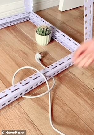 The video opens with the head of the electrical cord stuck on one side of the white shelving bracket