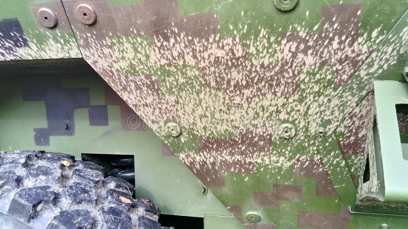 Dried mud on the sidewall of an armored war machine. Dry gray-brown clay on the khaki tank armor. Camouflage coloring of. Military equipment. Metal rivets, part royalty free stock photos