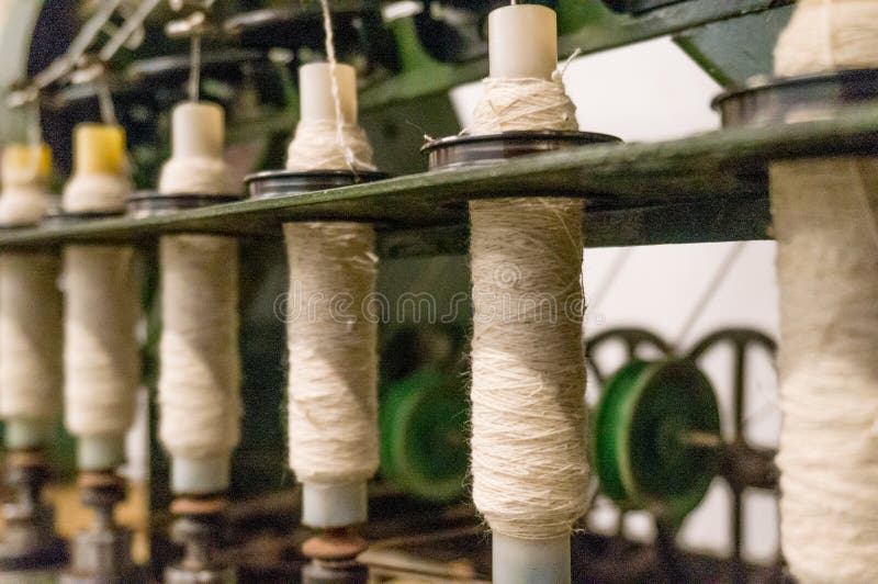 Green spindle weaving machine used to make cloth. The multiple spools of thread and the mechanized system helps make the cloth making process easier and royalty free stock image