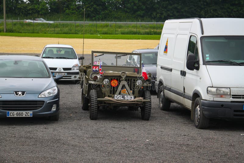 Normandy, France; 4 June 2014: U.S. Army Jeep Vehicle Used in 1944 between modern cars. Metal willys war transport camp armored old off-road historic caliber royalty free stock images